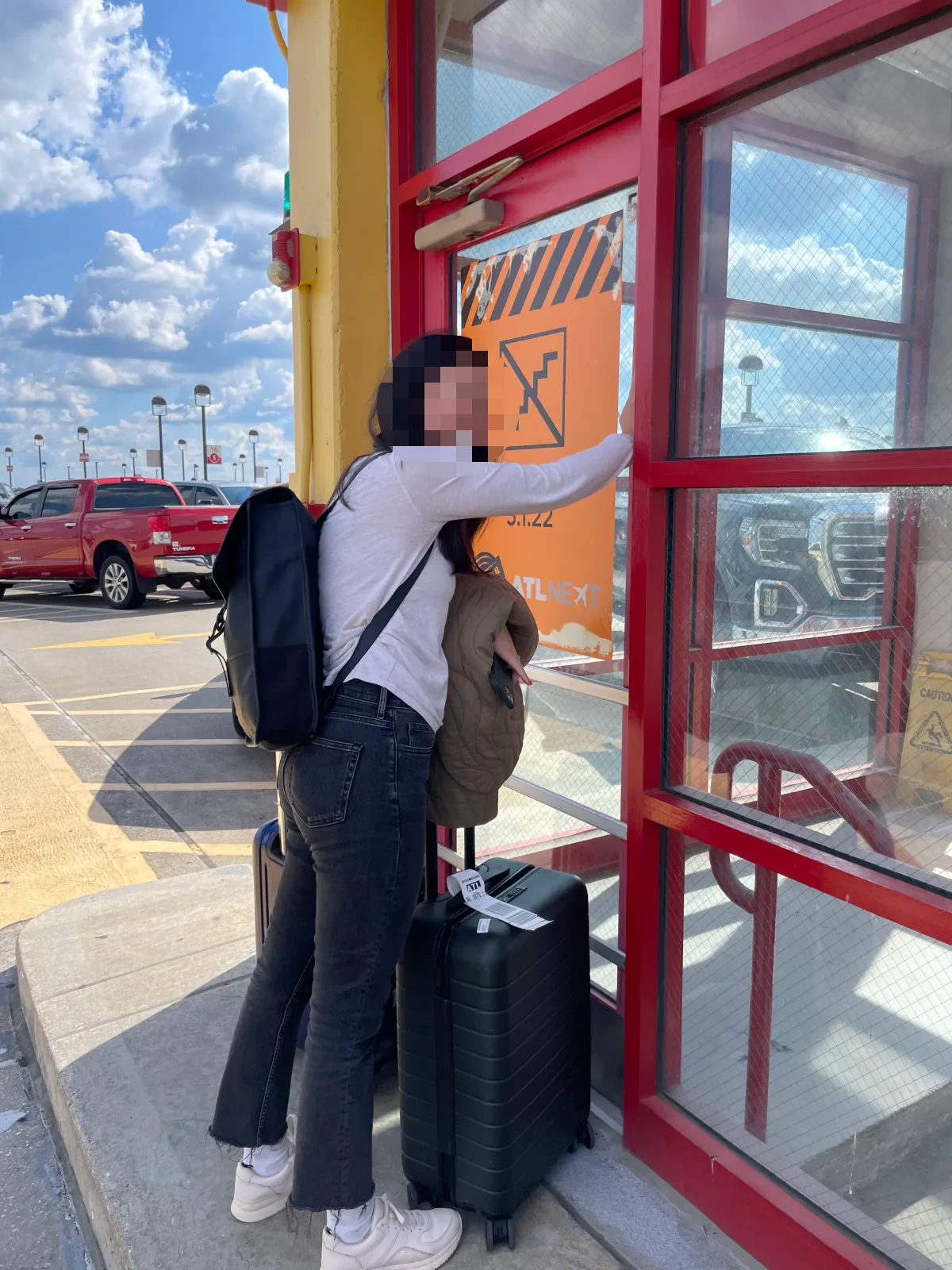 A team member at a garage stairwell door, its orange sign announcing the stairs closed on 5.1.22